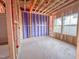 Exposed framing reveals room under construction, showcasing the bones of a house with natural light from two windows at 205 Pond Vw Ct # 2, Fuquay Varina, NC 27526