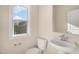 Cozy half bathroom with pedestal sink, toilet, window and neutral paint at 207 Pond View Ct # 3, Fuquay Varina, NC 27526