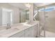 Bright bathroom featuring double vanity, quartz countertop, and tiled shower with glass door at 207 Pond View Ct # 3, Fuquay Varina, NC 27526