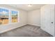 This bedroom features neutral carpet, paint, and trim, plus two bright windows and a closet door at 207 Pond View Ct # 3, Fuquay Varina, NC 27526