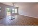 Spacious bedroom with a ceiling fan, three large windows, wood floors, and access to the deck at 207 Pond View Ct # 3, Fuquay Varina, NC 27526