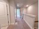 Upstairs hallway showcasing neutral carpet, doors to rooms and access to attic space at 207 Pond View Ct # 3, Fuquay Varina, NC 27526