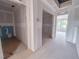 Unfinished hallway, showing a future bathroom on the left and a bright, window-filled bedroom at the end at 207 Pond View Ct # 3, Fuquay Varina, NC 27526