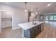 Open floor plan kitchen with an island sink, white cabinetry, and stainless steel appliances at 207 Pond View Ct # 3, Fuquay Varina, NC 27526