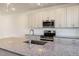 Modern kitchen features stainless steel appliances, granite countertops, and gray shaker-style cabinetry at 207 Pond View Ct # 3, Fuquay Varina, NC 27526