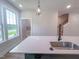 Bright kitchen island features stainless steel sink, and view of stairs and an open living area at 207 Pond View Ct # 3, Fuquay Varina, NC 27526
