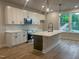 Open kitchen with quartz countertops, shaker cabinets, stainless steel appliances, and wood-look floors at 207 Pond View Ct # 3, Fuquay Varina, NC 27526