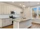Well-lit kitchen with stainless appliances, granite counters, island and modern pendant lighting at 207 Pond View Ct # 3, Fuquay Varina, NC 27526