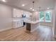 Open kitchen features white cabinets, an island with stone countertops, and stainless appliances at 207 Pond View Ct # 3, Fuquay Varina, NC 27526