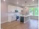 This kitchen boasts white cabinets, a modern island, stainless steel appliances, and pendant lighting at 207 Pond View Ct # 3, Fuquay Varina, NC 27526