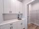 Convenient laundry room featuring white cabinetry, modern hardware, and a stylish backsplash at 207 Pond View Ct # 3, Fuquay Varina, NC 27526