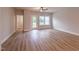 Bright, open living room with wood-look flooring, a ceiling fan, and access to the outdoors at 207 Pond View Ct # 3, Fuquay Varina, NC 27526