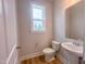 Stylish powder room with pedestal sink, modern fixtures, and a large window at 207 Pond View Ct # 3, Fuquay Varina, NC 27526