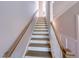 Staircase with neutral walls, white risers, and wood handrail at 207 Pond View Ct # 3, Fuquay Varina, NC 27526