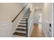 Interior staircase featuring hardwood stairs, white risers, and a dark wood railing at 207 Pond View Ct # 3, Fuquay Varina, NC 27526