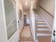 Hallway showcasing wood floors, staircase, and neutral decor at 209 Pond View Ct # 4, Fuquay Varina, NC 27526