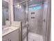 Walk-in tiled shower with a glass enclosure, shower niche, and overhead window at 209 Pond View Ct # 4, Fuquay Varina, NC 27526