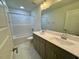 Bathroom with double sink vanity, a large mirror, and a shower over tub at 262 Grand Griffon Way, Lillington, NC 27546