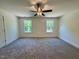 Bright bedroom with neutral carpet, ceiling fan, and natural light streaming in from the windows at 262 Grand Griffon Way, Lillington, NC 27546