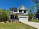 Beautiful two-story home with a stone accented entrance, gray siding and a two car garage at 262 Grand Griffon Way, Lillington, NC 27546