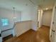 Upstairs hallway featuring hardwood floors and natural light from the nearby window at 262 Grand Griffon Way, Lillington, NC 27546