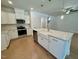 Kitchen with white cabinets, stainless appliances, and a large island with a farmhouse sink at 262 Grand Griffon Way, Lillington, NC 27546