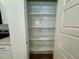 A well-lit, walk-in pantry with white shelving offering ample storage space for dry goods and kitchen supplies at 262 Grand Griffon Way, Lillington, NC 27546