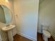 Simple powder room featuring a pedestal sink and toilet on hardwood floors at 262 Grand Griffon Way, Lillington, NC 27546