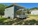 Backyard with covered porch area features gray siding, a bright lawn and a wooded area at 45 Covey Rise Way, Lillington, NC 27546