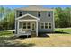 Backyard with covered porch, green siding, and an array of bright windows at 45 Covey Rise Way, Lillington, NC 27546