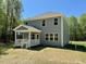 Two-story home features a covered porch and an array of windows overlooking the backyard at 45 Covey Rise Way, Lillington, NC 27546