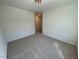 A carpeted bedroom with a ceiling light and a view into the hallway at 45 Covey Rise Way, Lillington, NC 27546