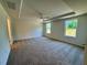 Primary bedroom with a tray ceiling, ceiling fan, carpeted floors and windows with views of the large yard at 45 Covey Rise Way, Lillington, NC 27546
