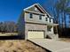 Two-story house with gray siding, stone accents, and attached garage at 45 Covey Rise Way, Lillington, NC 27546