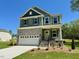 Exterior of a two-story home with stone accents, a two-car garage, and a manicured lawn at 45 Covey Rise Way, Lillington, NC 27546