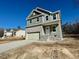 Two-story house with gray siding, stone accents, and attached garage at 45 Covey Rise Way, Lillington, NC 27546