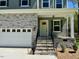 Charming home exterior showcasing stone accents, a covered porch, and a two-car garage at 45 Covey Rise Way, Lillington, NC 27546