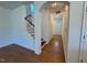 Hallway with hardwood floors, staircase, and entry door providing a bright and welcoming atmosphere at 45 Covey Rise Way, Lillington, NC 27546