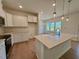 Bright, white kitchen featuring an island with bar seating, modern pendant lighting, and stainless steel appliances at 45 Covey Rise Way, Lillington, NC 27546