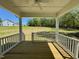 Covered porch with wooden floors and white railings overlooks a grassy backyard at 45 Covey Rise Way, Lillington, NC 27546