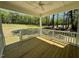 View of a covered porch with ceiling fan, looking out onto a large, green backyard at 45 Covey Rise Way, Lillington, NC 27546