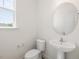 Bathroom with toilet, sink, mirror, and window at 63 Whimbrel Ct, Lillington, NC 27546
