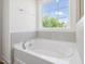 Modern bathtub with chrome fixtures is set against a window offering natural light at 63 Whimbrel Ct, Lillington, NC 27546