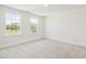 Light filled bedroom with two large windows and neutral carpet at 63 Whimbrel Ct, Lillington, NC 27546