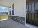 Inviting front porch with stone accents and a well-manicured lawn at 63 Whimbrel Ct, Lillington, NC 27546