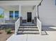 Inviting front porch with stone accents and a well-manicured lawn at 63 Whimbrel Ct, Lillington, NC 27546