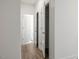 Hallway with doors and wood-look floors and white walls at 63 Whimbrel Ct, Lillington, NC 27546