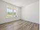 Bright room with light wood-look flooring, two windows, and white walls at 63 Whimbrel Ct, Lillington, NC 27546