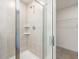 Walk-in shower featuring glass door, white tiles, and built-in shelving, offering a luxurious spa-like experience at 63 Whimbrel Ct, Lillington, NC 27546