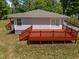 A spacious wooden deck with red railing offers space for relaxing and entertaining at 670 Mcadams Rd, Hillsborough, NC 27278